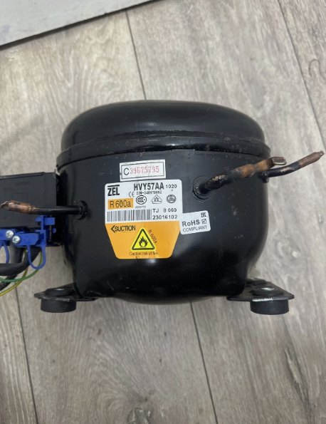 Fridge compressor photographed separately from the appliance